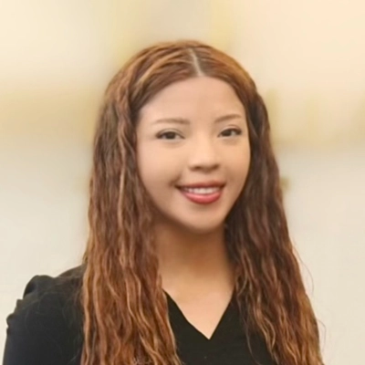 Cinthia Carbajal smiling with long wavy hair.