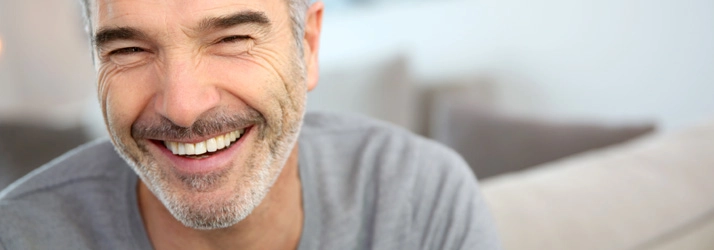 Chiropractic Ocoee FL Happy Man Smiling A man smiling. He has a short grey beard.