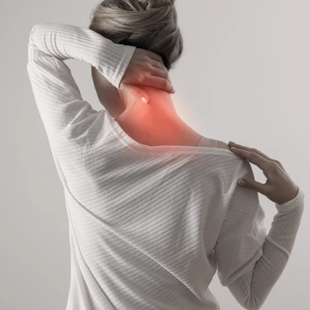 A woman holding her neck. Her neck is red.