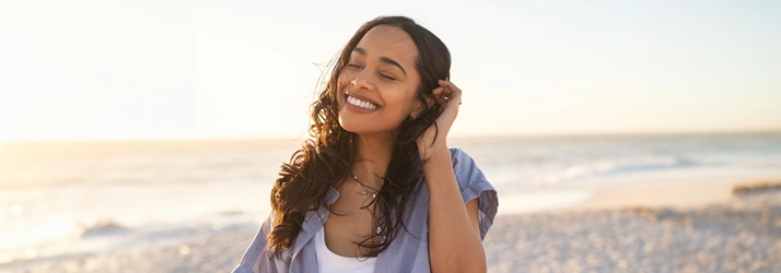 Chiropractic Ocoee FL Woman On The Beach Smiling woman walking on the beach.